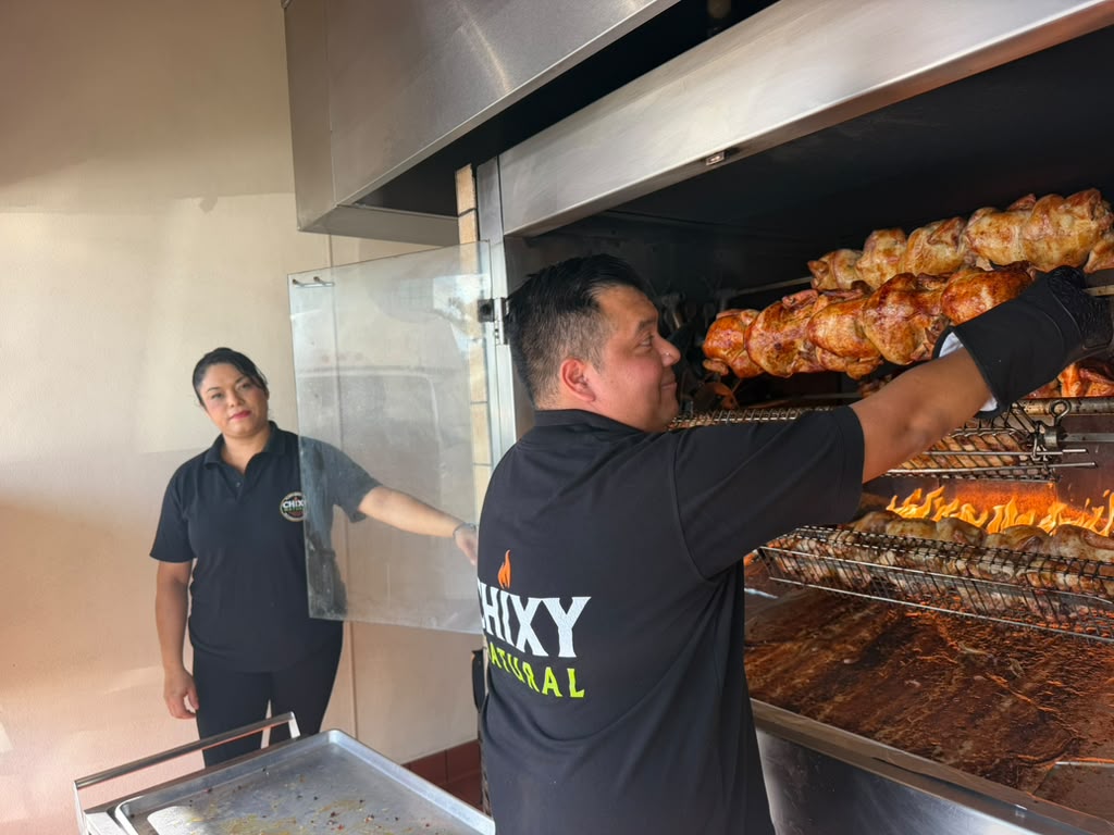 Chixy Natural team tending chickens on the rotisserie
